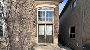 A building entrance with a double door, steps leading up to it, and a snow-covered ground. - Sophisticated 2-Story Classic Home (Brampton)