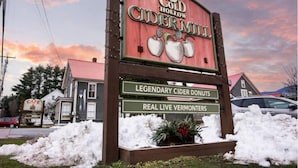 A sign for Cold Hollow Cider Mill with a backdrop of a sunset sky. - The Cider Loft (Waterbury)