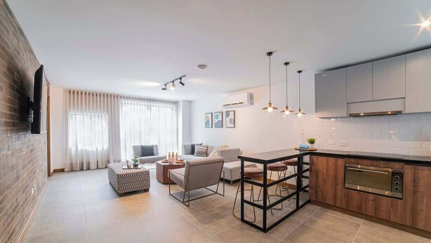 A modern kitchen with a central island, built-in appliances, and pendant lighting. - E201 - Spacious 2-bed / 2-bath, A/C & Fast WiFi (Cali)