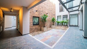 A modern building with a brick exterior, a tiled courtyard, and a glass structure. - E103 - Brand-New Quiet & Comfortable Studio Unit (Cali)