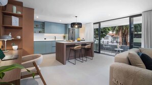 Une cuisine moderne dotée d’un îlot central, de tabourets de bar et d’un coin repas avec un canapé et une table.