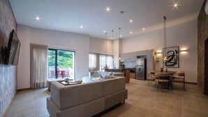 A modern living room with a sofa, dining table, and kitchen area. - E302 - Luxurious Top Floor Apartment with Terrace (Cali)