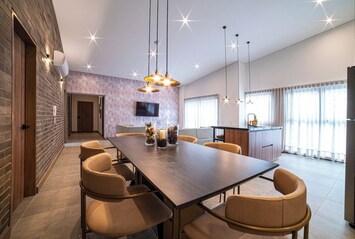 Spacious open layout with dining table, kitchen with bar and living area with SmartTV.