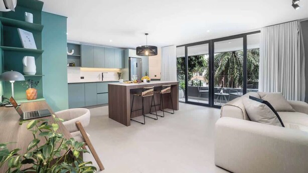 A modern living room with a sofa, a dining area with a bar, and a kitchen. - Hygge 301 - 2-Bed Beauty | Balcony | Near Granada (Cali)
