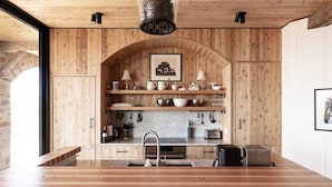 Una cocina moderna con paneles de madera, encimera de mármol y horno empotrado.