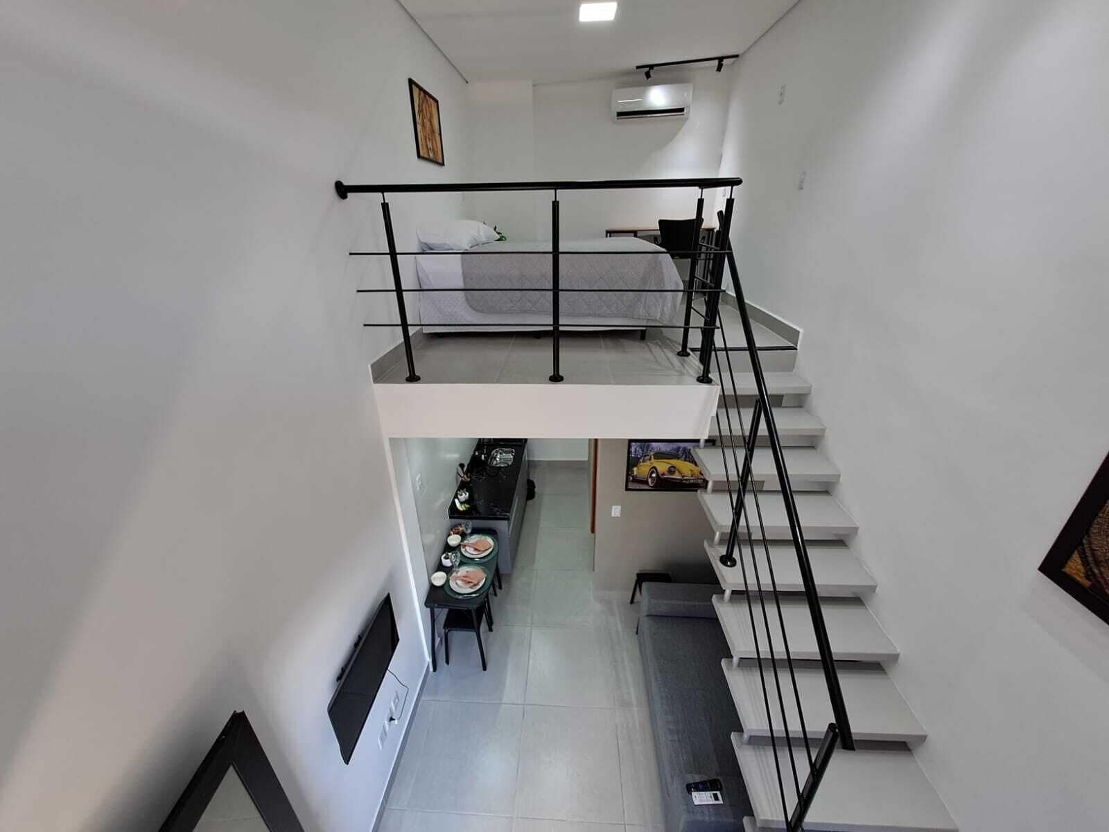 Un appartement moderne doté d’une chambre en mezzanine, d’un coin repas et d’une cuisine.