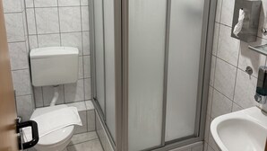 A bathroom with a glass-enclosed shower, a toilet, and a sink. - Eurocity Hotel (Bruchkoebel)