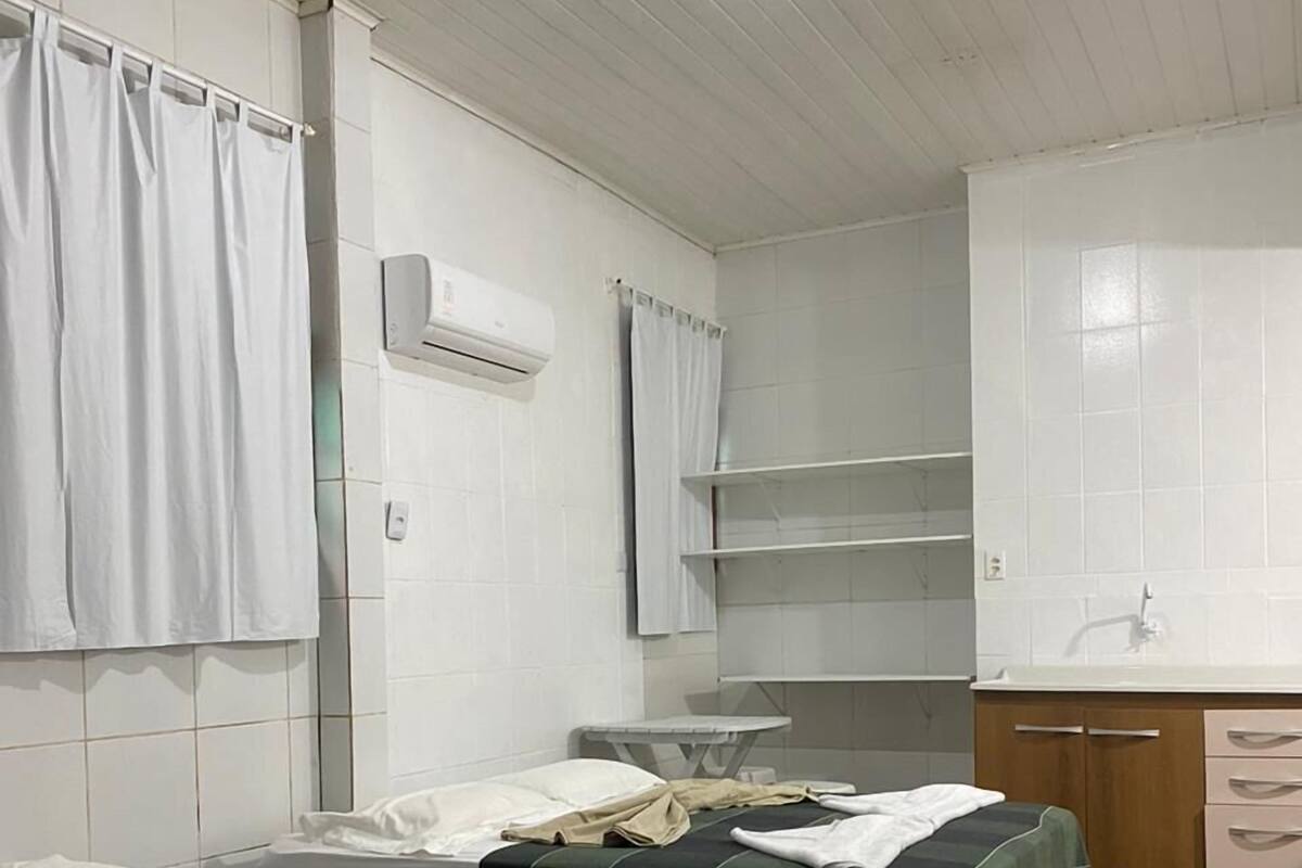Una habitación con dos camas, un lavabo y un armario.