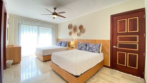 A hotel room with two beds, a ceiling fan, a wooden door, and a window with sheer curtains. - 2BR 6 Guest Balcony in Portillo Close to Beach (Las Terrenas)
