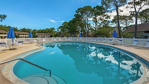 Relax by the pool surrounded by lounge chairs and umbrellas.