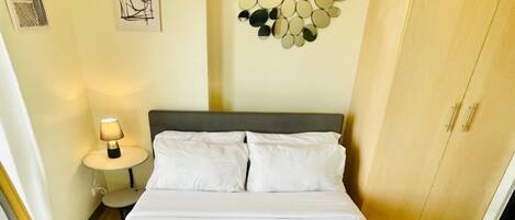 Tabla de planchar con plancha y ropa de cama