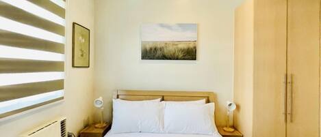 Tabla de planchar con plancha y ropa de cama