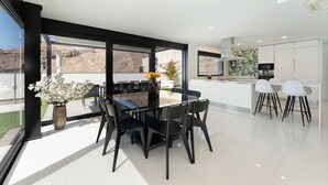 A modern kitchen with white cabinets, a black countertop, and a built-in oven.