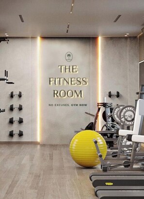 Une salle de sport dont les murs sont ornés de citations motivantes et qui est équipée de divers appareils d’exercice.