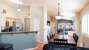 A spacious kitchen with a dining area, featuring a large island, modern appliances, and a ceiling fan. - Rita Ranch Retreat - Cozy 4 BD (Tucson)