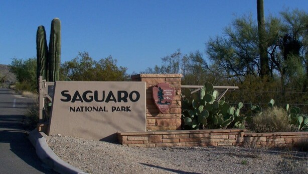 A sign for Saguaro National Park with a cactus and desert landscape in the background. - Rita Ranch Retreat - Cozy 4 BD (Tucson)