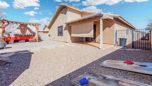 A house with a sloped roof, a covered patio, and a gravel driveway. - Rita Ranch Retreat - Cozy 4 BD (Tucson)