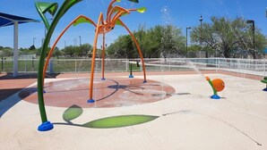 An outdoor water play area with a large spider sculpture and water jets. - Rita Ranch Retreat - Cozy 4 BD (Tucson)