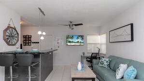 A modern kitchen with a bar area, a dining table with chairs, a sofa, and a ceiling fan. - 1bd 1bth , PYT , Airport , MPT (Fort Lauderdale)