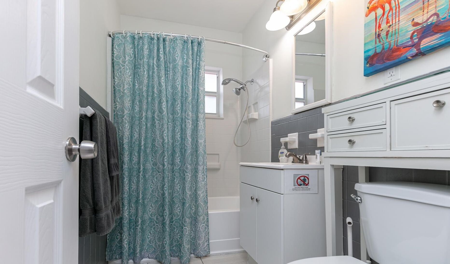 A bathroom with a shower, toilet, and sink.
