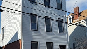A white two-story building with multiple windows, a visible chimney, and a brick foundation. - Diamond in the Burgh (Pittsburgh)
