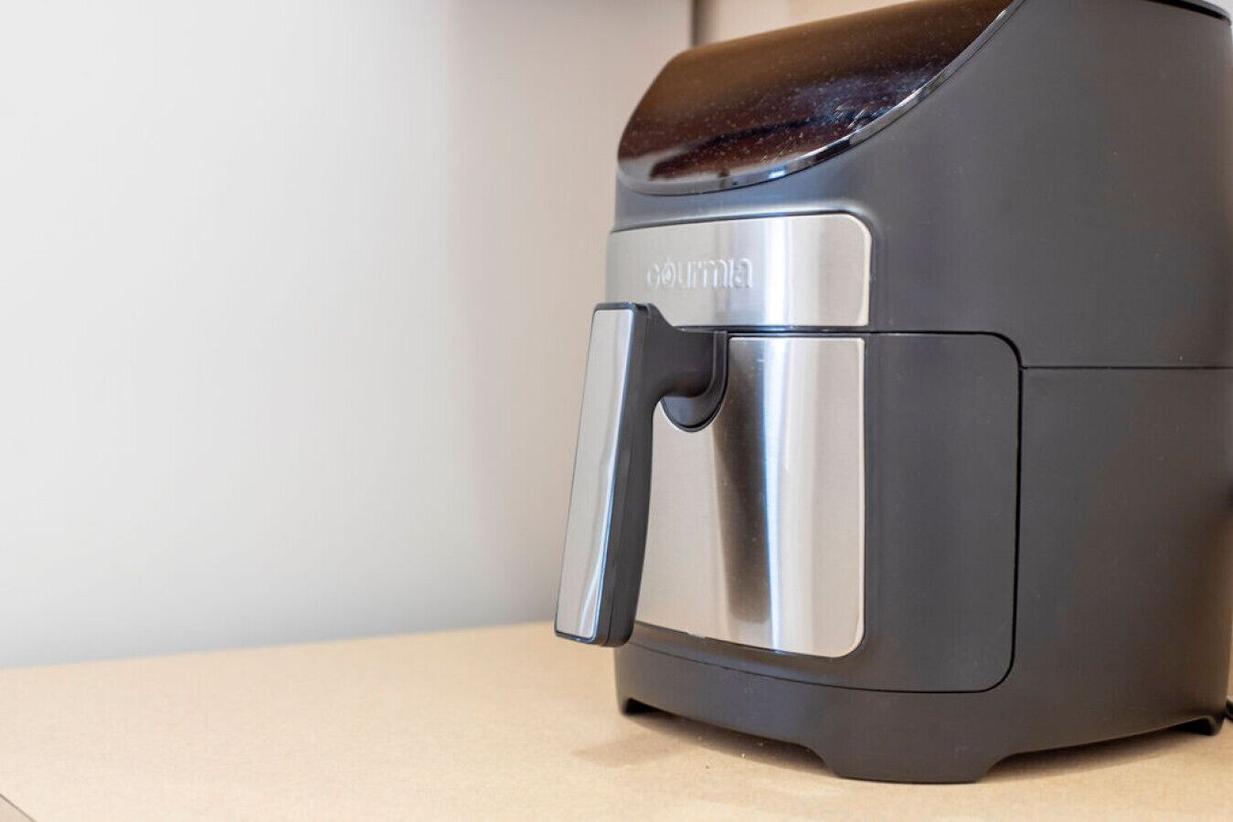 A compact, modern kitchen appliance with a stainless steel handle and a dark top.
