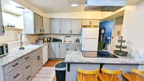 A compact kitchen with a refrigerator, microwave, sink, and bar stools. - Fort Huachuca. Home with private Gym. Pet with fee (Sierra Vista)