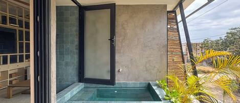 Une salle de bain moderne dotée d’une porte en verre, d’une baignoire intégrée et offrant une vue sur les environs.