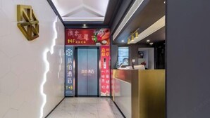 A hotel reception area with a modern design, featuring a reception desk, a digital display, and a sign with directional arrows. - 100 Inn (Zhoupu Wanda) (Shanghai)