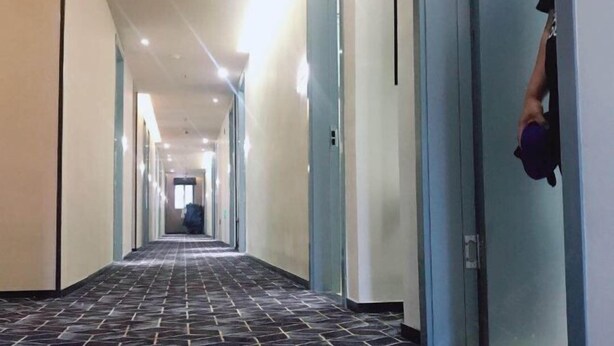 A long, narrow hotel corridor with a patterned floor and light-colored walls. - 100 Inn (Zhoupu Wanda) (Shanghai)