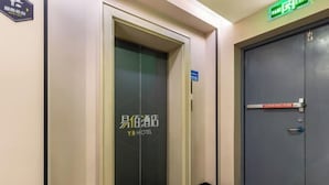 An elevator with a sign for Y.B Hotel, a door with a blue sign, and a tiled floor. - 100 Inn (Zhoupu Wanda) (Shanghai)