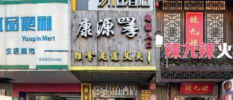 A street view with various storefronts, including a pharmacy, a convenience store, and a restaurant.