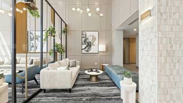 A modern lobby with a sofa, chairs, a coffee table, and a large abstract painting.