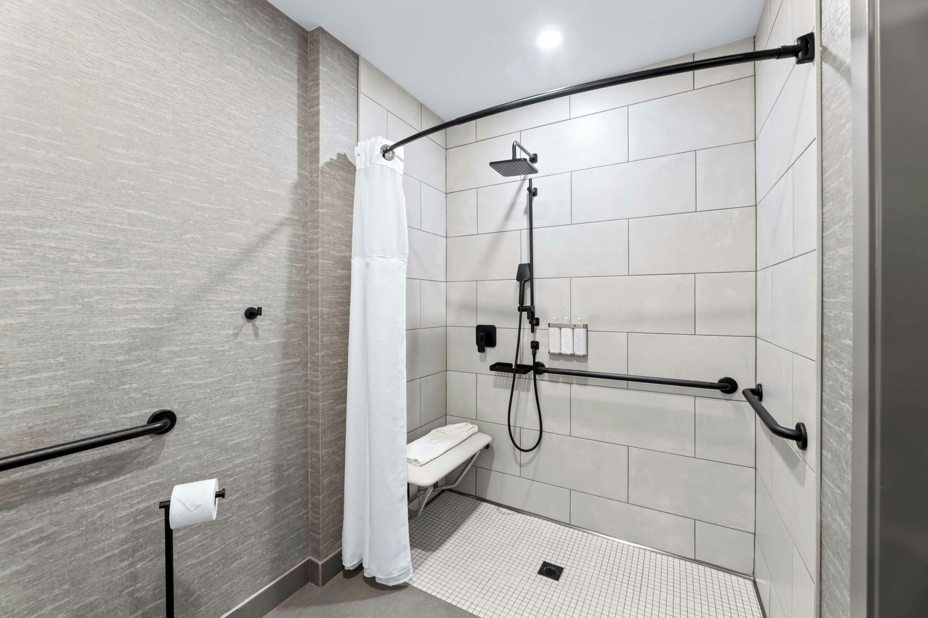 Un bagno moderno con doccia a filo pavimento, un water e un porta asciugamani.