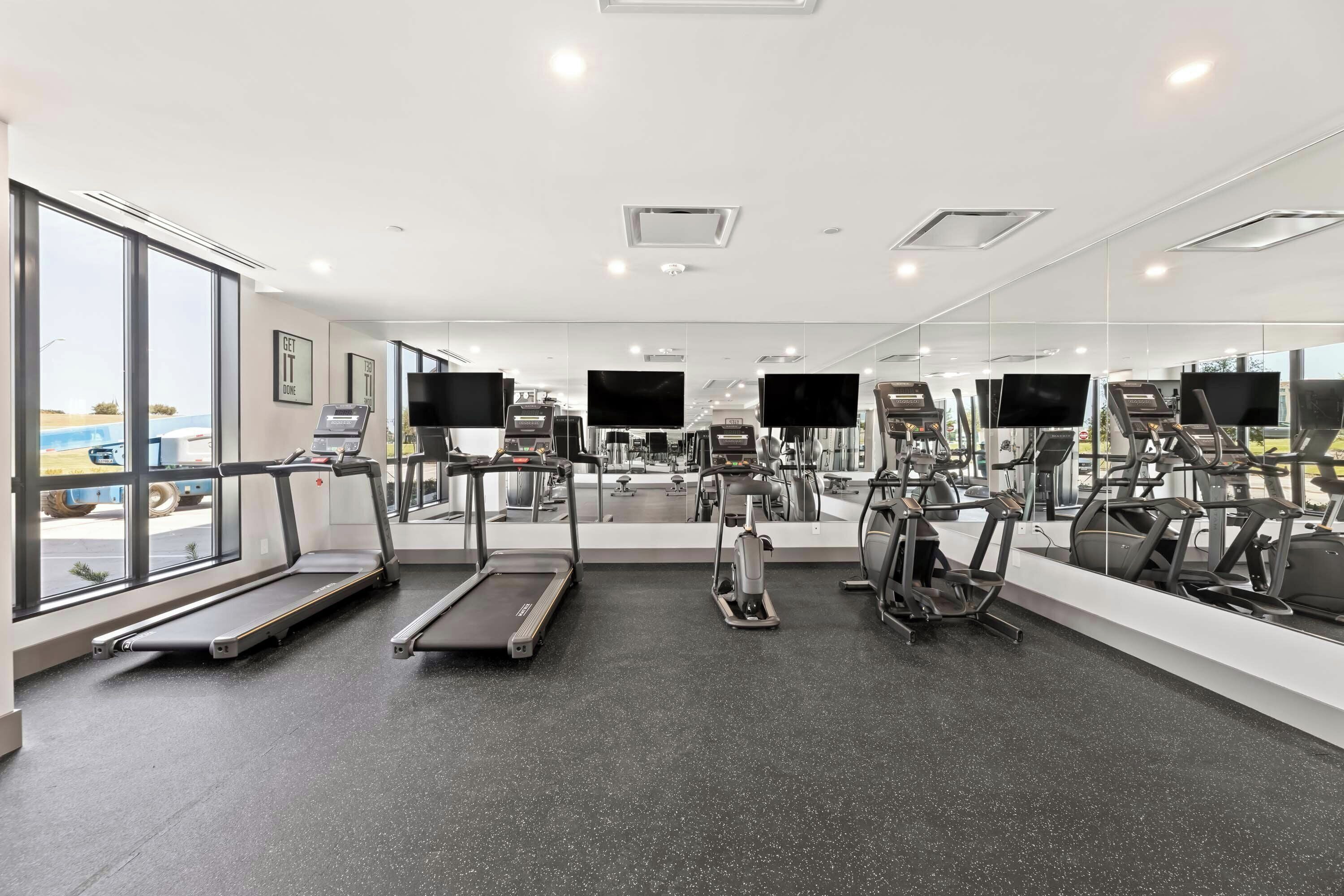 A modern gym with treadmills, stationary bikes, and exercise equipment.