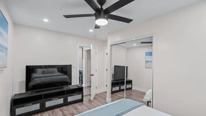 A modern bedroom with a bed, TV, and entertainment unit.