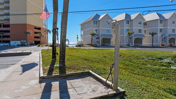 A beachfront hotel with multiple buildings, a sandy beach, and an American flag. - Beachside Stay w/ Pool & Beach Access + Free Attraction Tickets! (Panama City Beach)