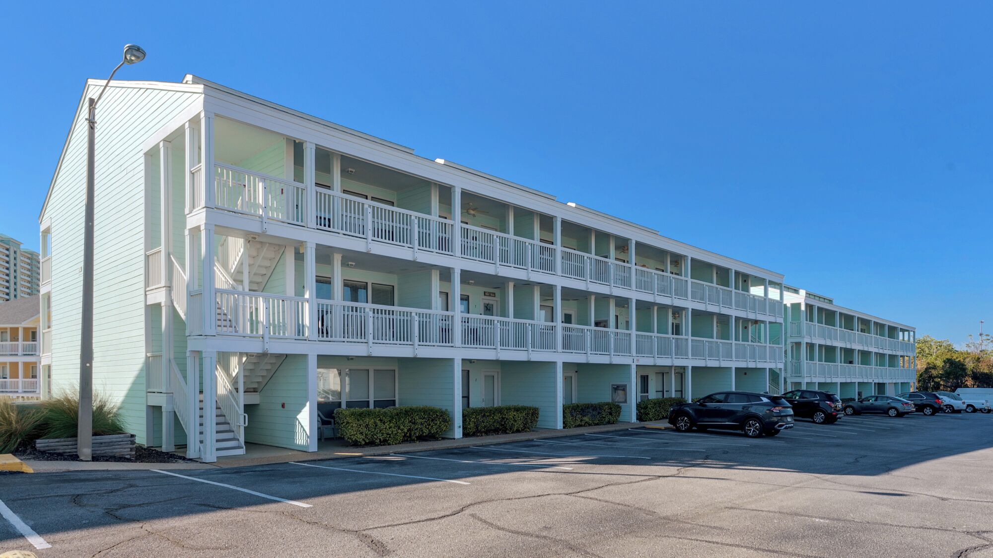 A multi-story motel with balconies and a parking lot.