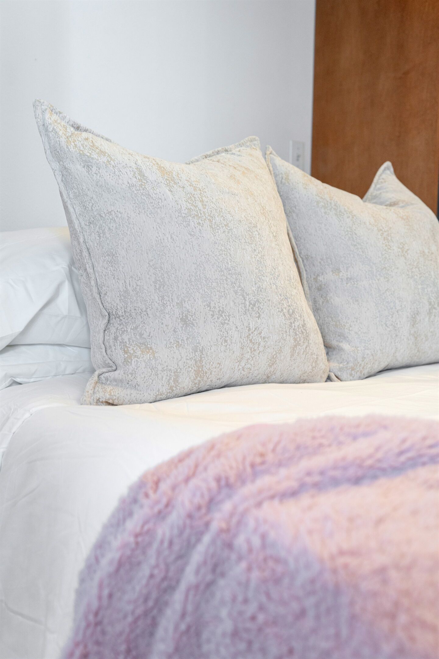 A bed with white bedding and two pillows.