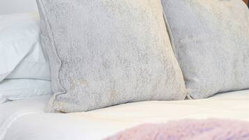 A bed with white bedding and two pillows.
