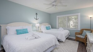 A room with two beds, a ceiling fan, a window with blinds, a wicker chair, and a lamp. - Walk to Harbour Town in 5 minutes! (Hilton Head Island)