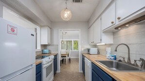 A modern kitchen with white appliances, blue cabinets, and a wooden countertop. - Walk to Harbour Town in 5 minutes! (Hilton Head Island)