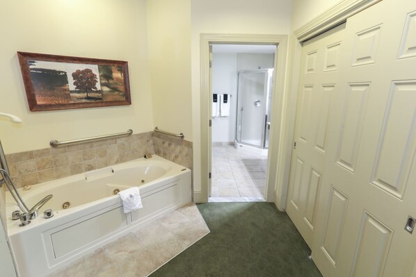 A bathroom with a bathtub, a towel rack, and a shower.