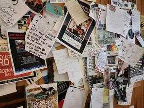 Una mesa desordenada con varias notas escritas a mano, carteles y folletos, incluyendo uno para 'The Brass Summer Concert' y otro para 'Northwest Honky Tonk'.