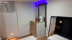 A modern room with a wooden cabinet, a coffee maker, a mirror, and a TV. - Private basement apartment in private house in vibrant Minneapolis (Minneapolis)