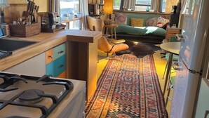 Interior compacto de autocaravana con kitchenette, zona de comedor y espacio de estar.