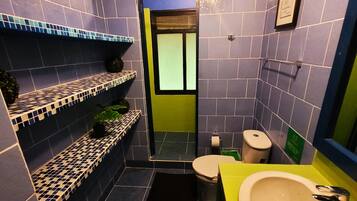 Casa de banho compacta com sanita, lavatório e prateleiras com plantas.
