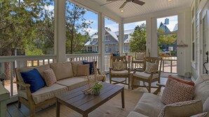 A covered porch with a sofa, chairs, and a coffee table. - 30A Stay With Pool & Beach Access + Free Attraction Tickets! (Santa Rosa Beach)