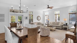 A spacious living room with a wooden dining table, two sofas, a coffee table, and a ceiling fan. - 30A Stay With Pool & Beach Access + Free Attraction Tickets! (Santa Rosa Beach)