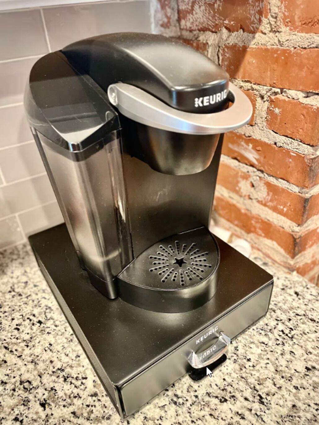 Une machine à café Keurig posée sur un plan de travail en granit.